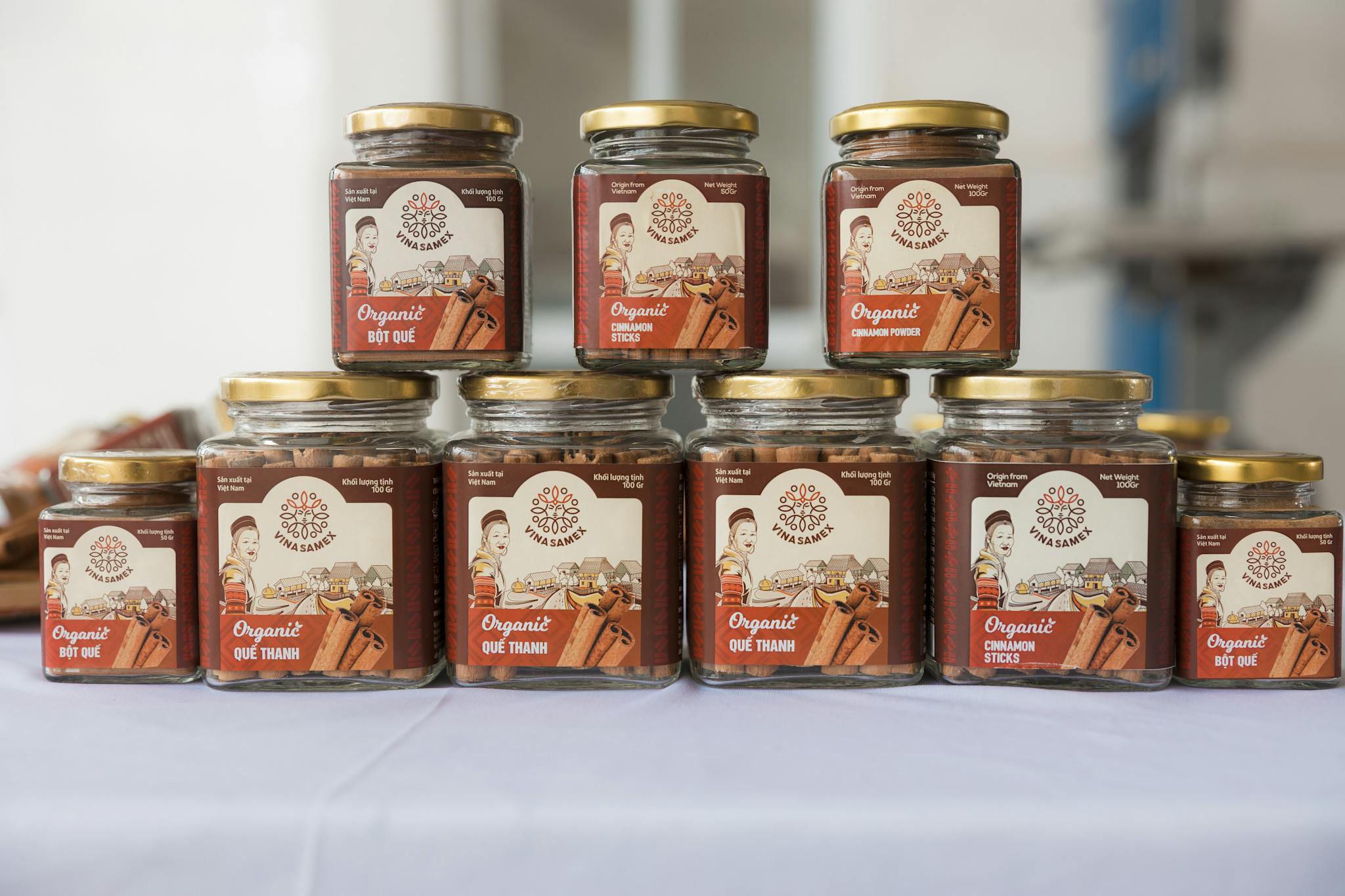 Organized display of organic cinnamon jars in glass containers on a table.